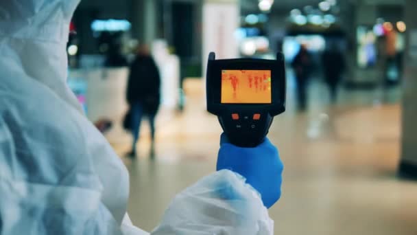 El trabajador médico está escaneando a los transeúntes con una cámara infrarroja — Vídeo de stock