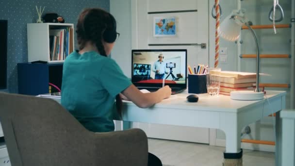 Girl taking part in a conference call using a laptop. Remote education, distant studying, on-line education concept. — Stock Video