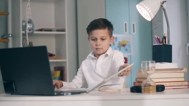 Kleiner Schüler lernt mit Tablet und Laptop aus der Ferne — Stockvideo