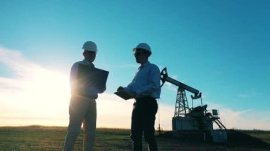 İki mühendis petrol çıkarma alanında bir projeyi tartışıyorlar. Petrol ve gaz endüstrisi kavramı.