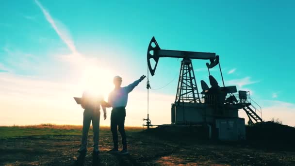 Concepto de la industria del petróleo y gas. Trabajadores de la energía masculina están observando un sitio de bombeo de petróleo — Vídeos de Stock