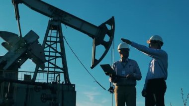 Enerji mühendisleri petrol geliştirme sahasında planları tartışıyorlar. Petrol ve gaz endüstrisi kavramı.