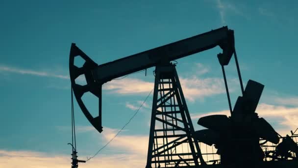 Концепция цен на нефть, газ, нефть. Pumpjack откачивает нефть с неба на заднем плане — стоковое видео