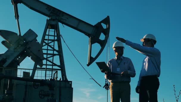 Az energiamérnökök az olajfejlesztési területen tárgyalnak a tervekről. Olaj- és gázipari koncepció. — Stock videók