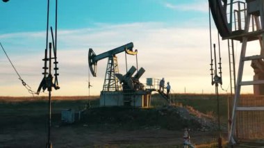 Mühendisler petrol pompalama sahasında sohbet ediyorlar.
