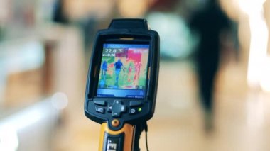 Ekranda sıcaklık göstergeleri olan termografik cihaz. Vücut sıcaklığı algılama, covid-19 önleme, koronavirüs konsepti.