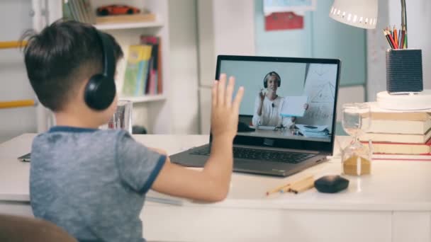 Un băiat își salută profesoara în timpul lecției online — Videoclip de stoc