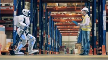 Depo çalışanı, robot nakliyesini kontrol ediyor