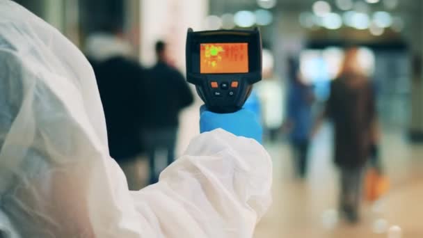 Experto médico está utilizando un dispositivo termográfico en un lugar público. Detección de temperatura corporal, prevención de covid-19, concepto coronavirus. — Vídeo de stock