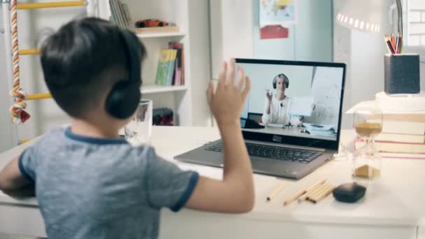Un băiat scrie în timp ce are o lecție pe internet — Videoclip de stoc