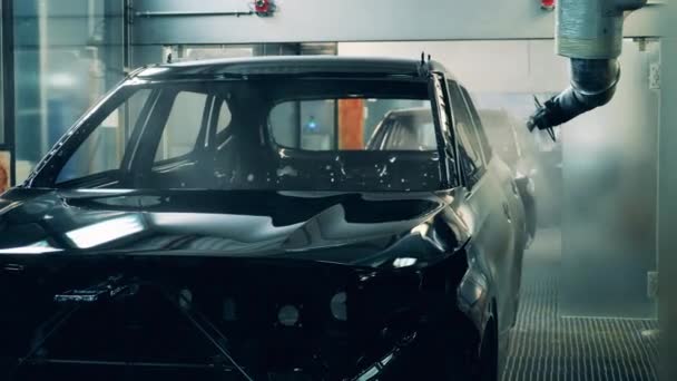 Fabrieksmachine spuit zink over een karkas van een auto — Stockvideo