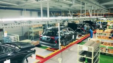 Araba fabrikasında üretim bandında duran parlak araba cesetleri.