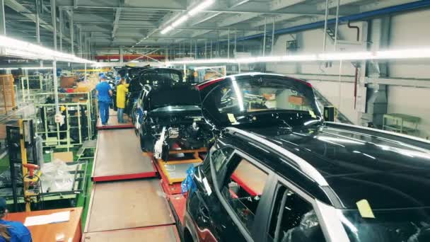 Industri otomotif, lini produksi mobil. Para pekerja menginstal suku cadang pada kendaraan di pabrik mobil — Stok Video