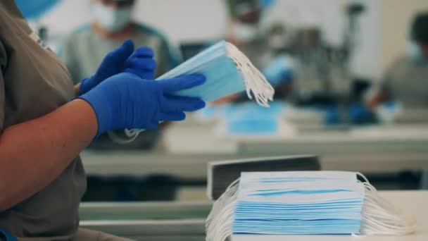 Female factory worker stacking face masks together — Stock Video