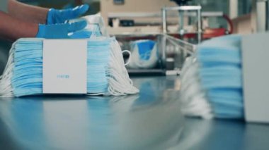 Coronavirus koruma maskesi üretim hattı. Polietilen ile sarılmış yüz maskeleri.