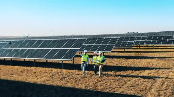 Tre ingegneri dell'energia solare stanno discutendo in una centrale solare — Video Stock