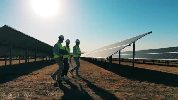 Ειδικοί ηλιακής ενέργειας περπατούν σε εγκατάσταση ηλιακής ενέργειας — Αρχείο Βίντεο