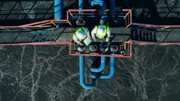 Vue de dessus de deux travailleurs sur le site de traitement des eaux usées — Video