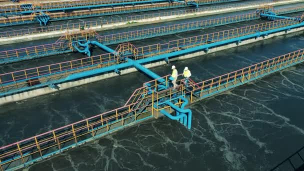 Technicians are walking along the wastewater facilities in a top view — Stock Video