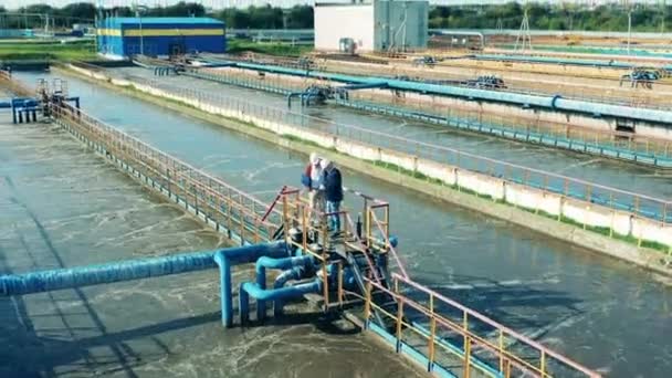 Dos técnicos en el complejo de tratamiento de aguas residuales en una vista superior — Vídeos de Stock