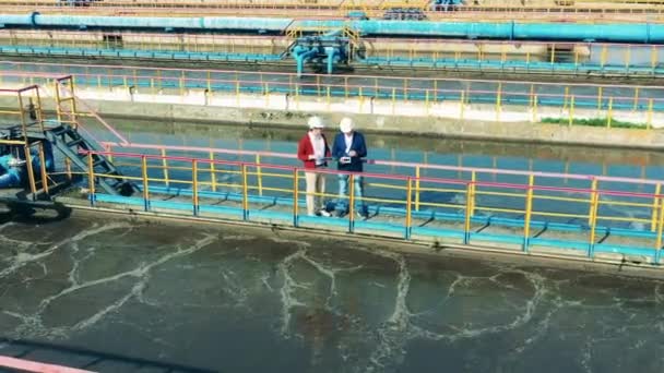 Trabajadores masculinos en el puente en el sitio de limpieza de aguas residuales — Vídeo de stock