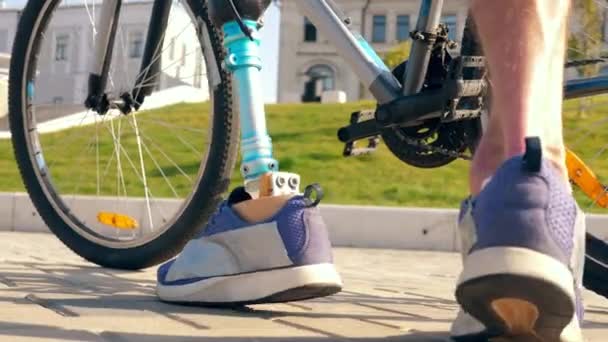 Gros plan d'une jambe bionique masculine en vélo — Video