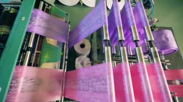 Vista superior de uma máquina de fabricação de sacos de plástico colorido. Processo de produção de películas de polietileno. — Vídeo de Stock