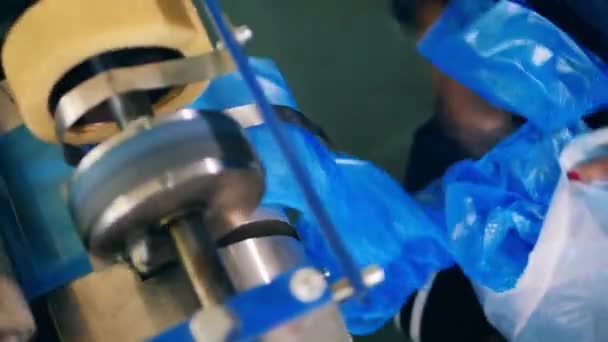 Fabrieksarbeider verzamelt blauwe plastic zakken uit een plastic zak productie machine — Stockvideo