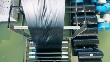 Polietilen üretim fabrikasındaki siyah plastik poşet üretim hattının üst görüntüsü. Polietilen çanta üretimi.