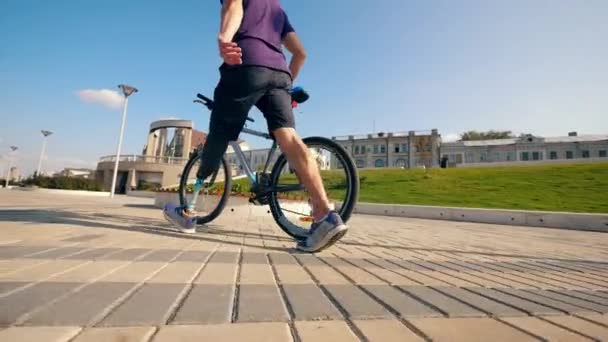 Un handicapé marche à vélo le long du quai — Video