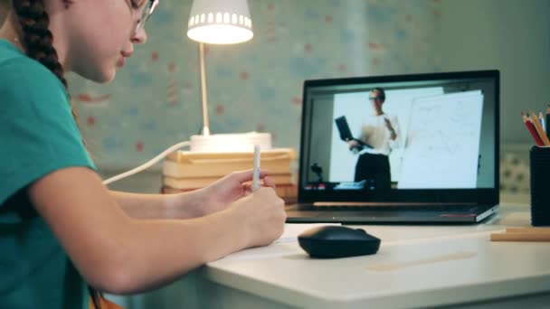 Schoolmeisje neemt deel aan een online klas van haar huis — Stockvideo
