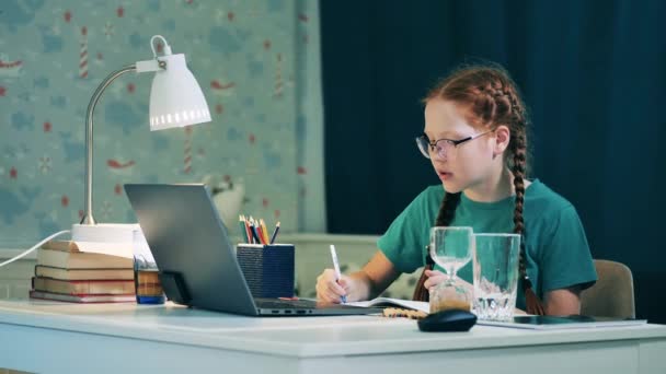 Školačka studuje vzdáleně ze svého domova pomocí počítače — Stock video