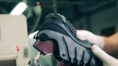 Ayakkabı uzmanı, bir ayakkabıyı son tahtadan çıkarıyor.