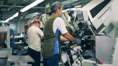 Ayakkabı fabrikası çalışanları ayakkabı üretiyor.