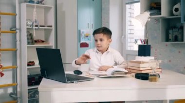 Öğrenci çocuk bilgisayarını kullanarak evden uzaktan çalışıyor. Uzaklık eğitimi, uzaklık öğrenimi, çevrimiçi eğitim, çevrimiçi sınıf kavramı.