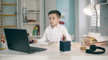 Öğrenci bilgisayarını internetten çalışmak için kullanıyor.