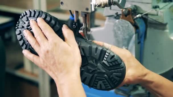 Fabriksarbetare syr en stövel med en symaskin — Stockvideo