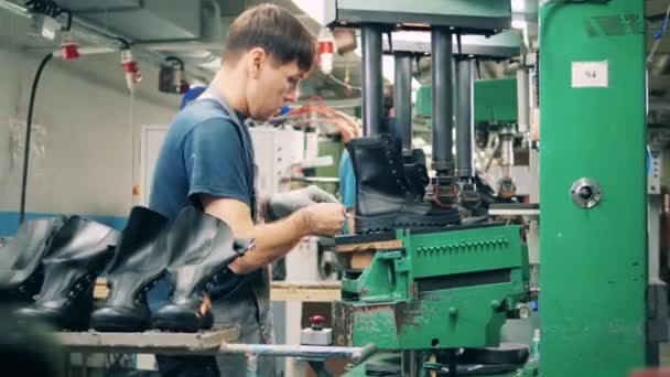 Male employee is cutting a boot out of a rubber sole — Stock Video