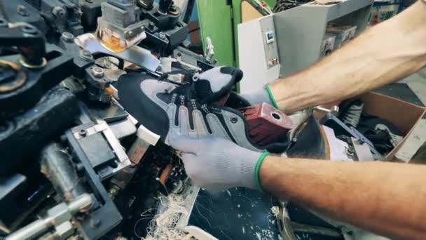 Trabajador del calzado está utilizando una máquina para ajustar un zapato — Vídeos de Stock