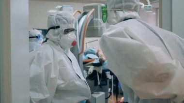 Güvenlik giysisi giyen doktorlar bir CVid-19 hastanesinde birbirleriyle konuşuyorlar..