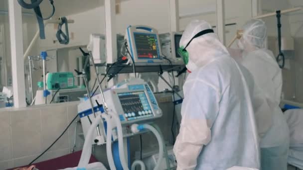 Médicos em trajes de proteção coronavírus estão gerenciando máquinas de ventilação na zona vermelha covid-19 ward — Vídeo de Stock