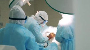 Covid-19 güvenlik önlüğü giyen cerrahlar bir operasyon gerçekleştiriyor.