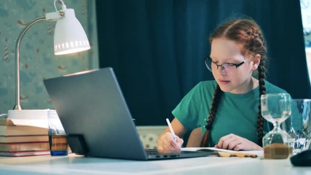Koncentrált iskolás lány tanul egy online órán. Távolsági oktatás, távoktatás, online oktatás, online osztály koncepció. — Stock videók