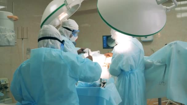 Operace je držena chirurgy v bezpečnostním oblečení — Stock video