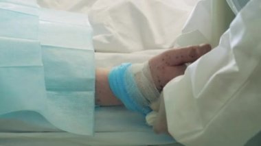 Sağlık çalışanı hastaların elini bandajlıyor.