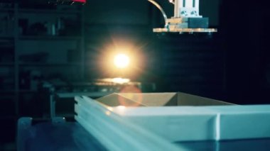 Robot mekanizması paketleri bir kutuya yerleştiriyor