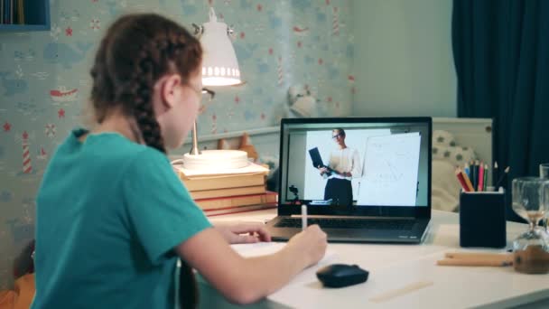Ein kleines Mädchen, das mit seinem Laptop ferngesteuert die Schule besucht. Fernausbildung durch die Lockdown-Klausel der Covid-19. — Stockvideo