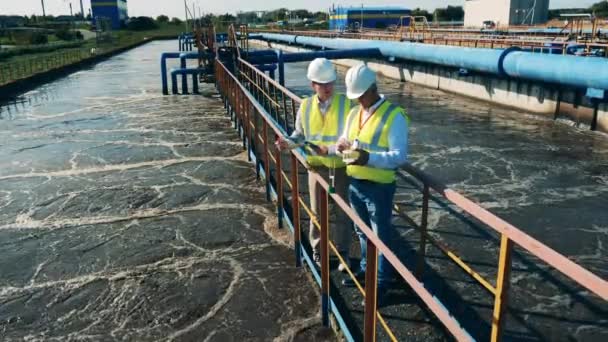 Ingenieros discuten instalaciones de tratamiento de aguas residuales — Vídeos de Stock