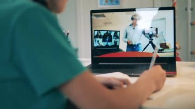 Uzaktan eğitim, online eğitim, online sınıf konsepti. Çevrimiçi bir derse katılan bir öğrencinin yakın plan fotoğrafı.