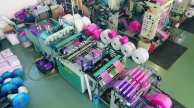 Üretim bandında plastik poşetleri sıralayan kadın işçi.